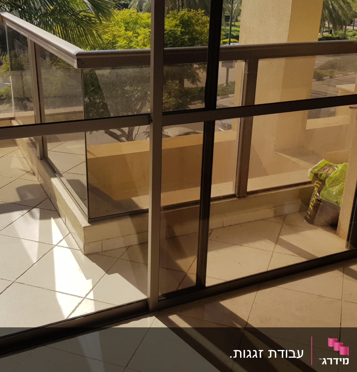 מעקה זכוכית במרפסת עם צל על הרצפה